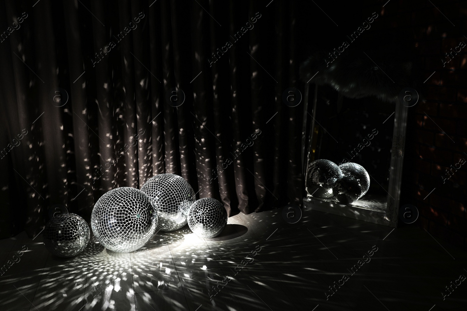 Photo of Many shiny disco balls in dark room