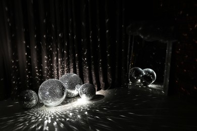 Photo of Many shiny disco balls in dark room