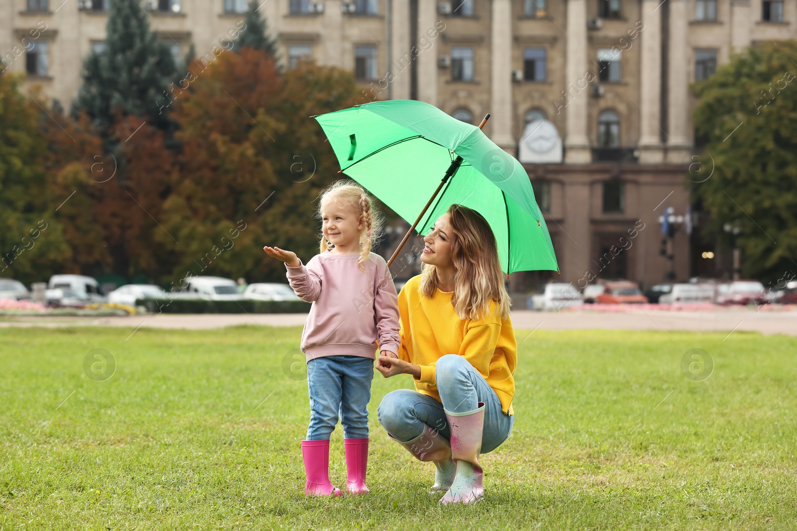 Photo of Happy mother and daughter with umbrella in park