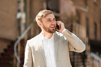 Portrait of young businessman talking on phone outdoors