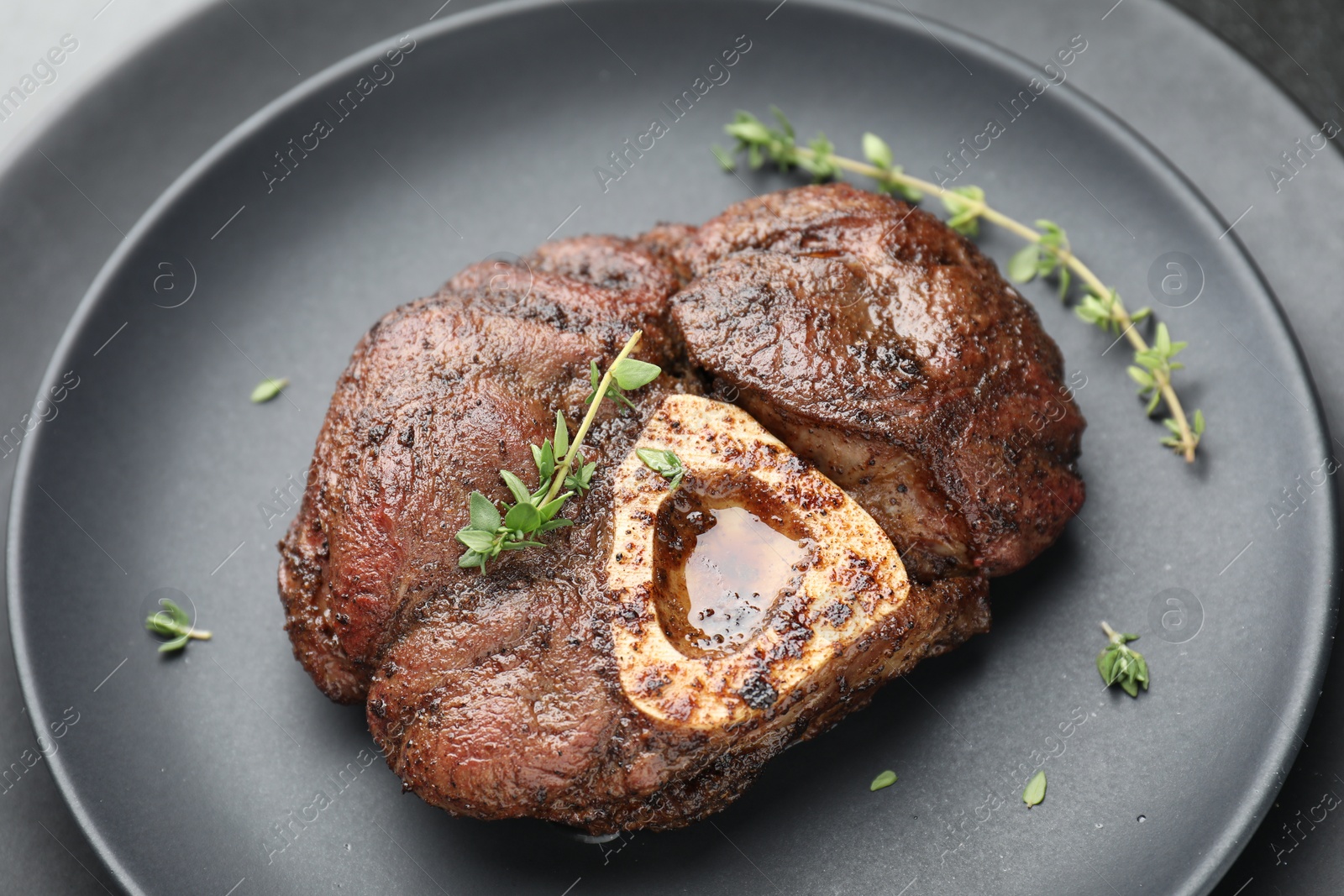 Photo of Delicious roasted beef meat with thyme on plate, closeup