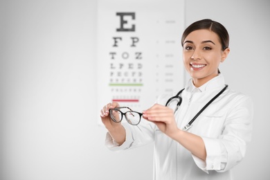 Female ophthalmologist with eyeglasses in clinic. Space for text
