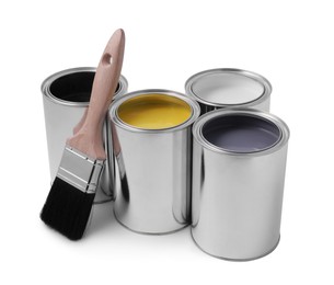 Photo of Cans of different paints with brush on white background