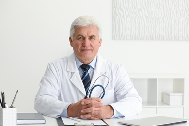 Photo of Portrait of senior doctor in white coat at workplace