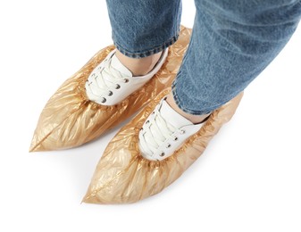 Woman wearing shoe covers onto her sneakers against white background, top view