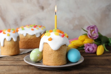 Photo of Easter cakes, colorful eggs and tulips on wooden table