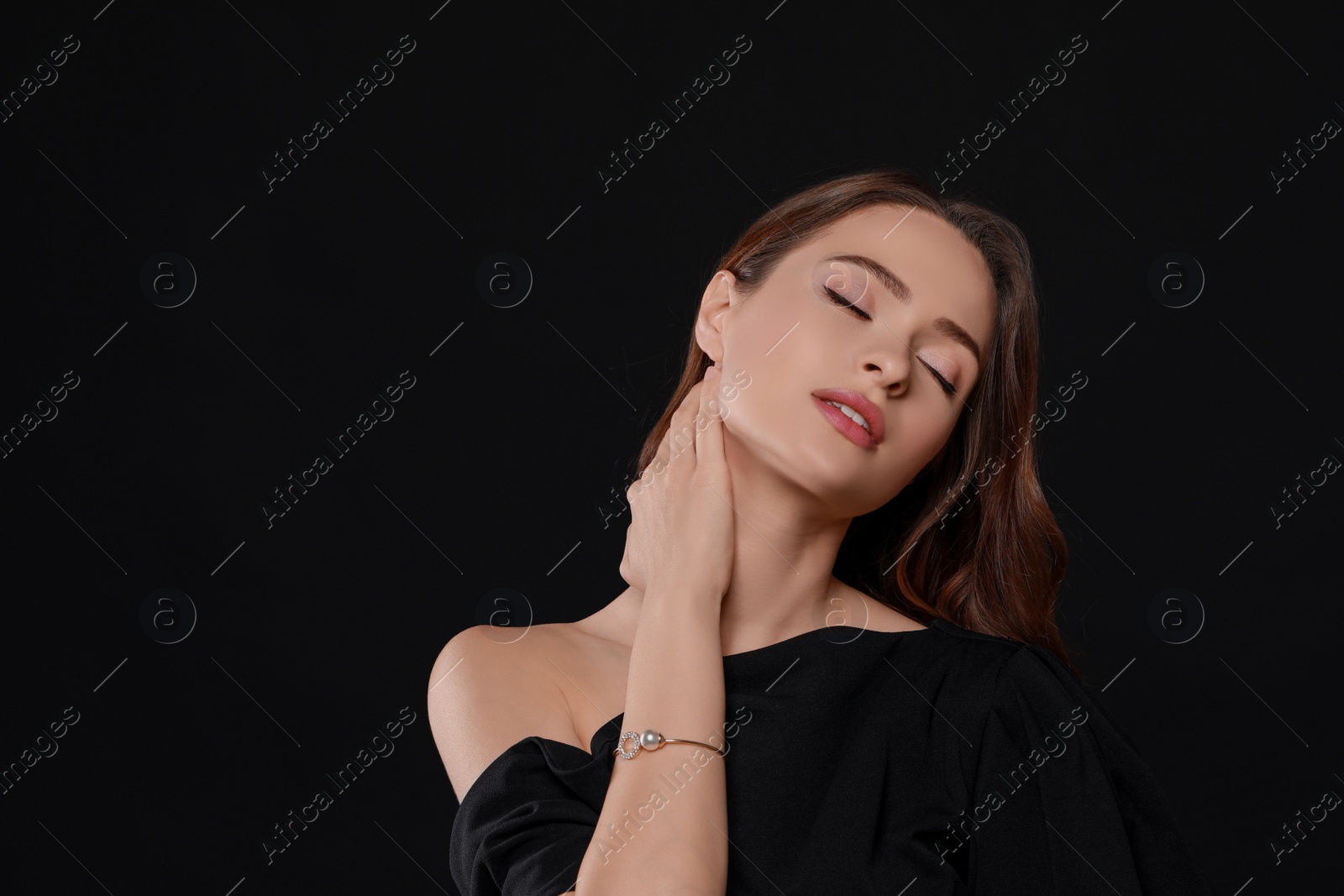 Photo of Young woman wearing elegant pearl bracelet on black background, space for text