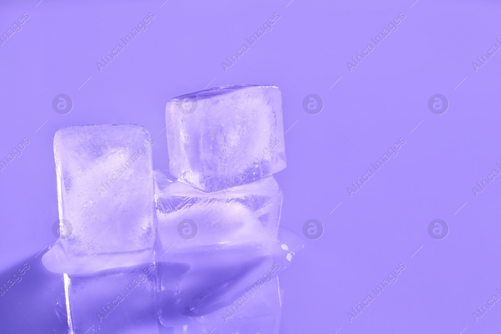 Photo of Ice cubes on color background. Space for text