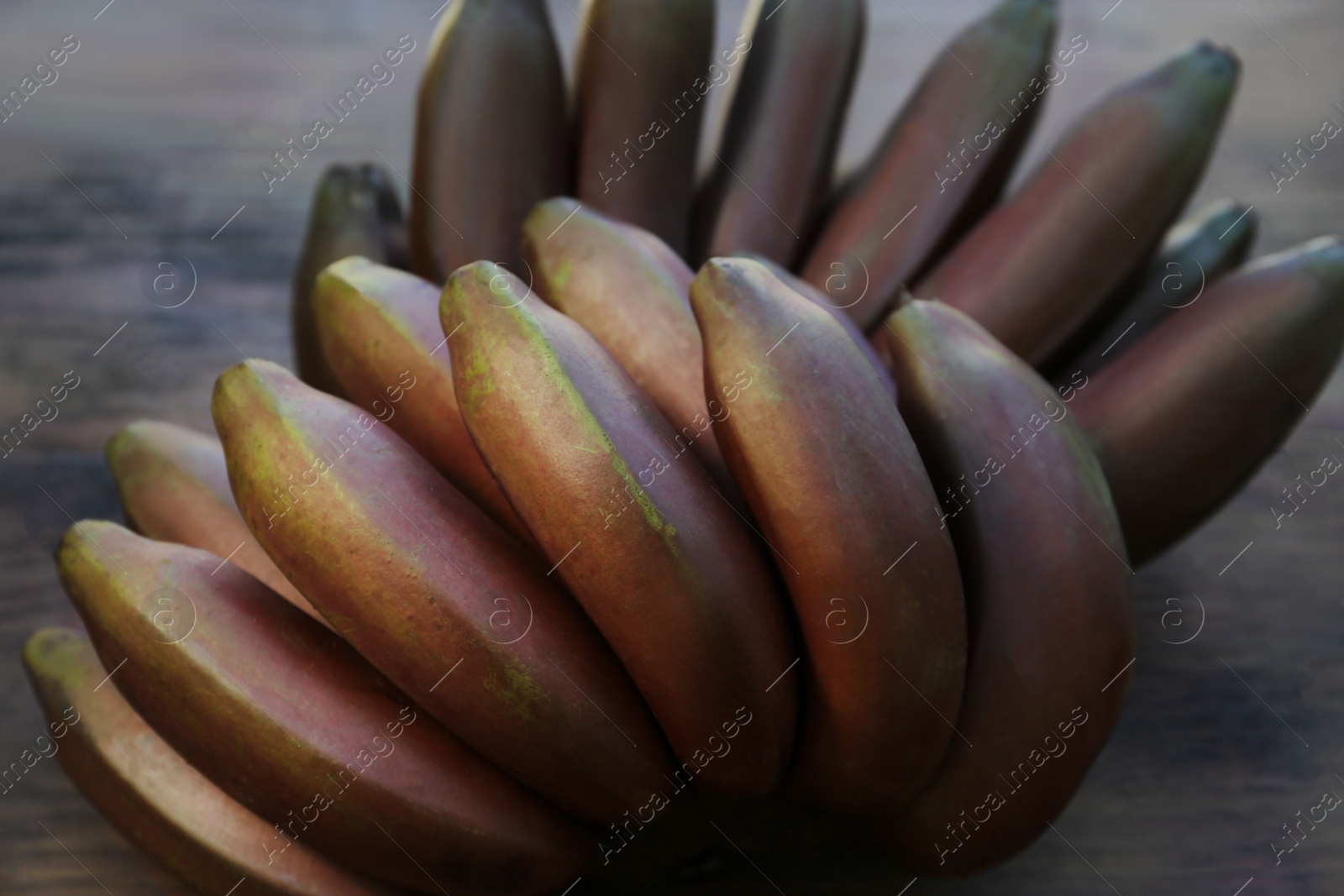 Photo of Tasty purple bananas on wooden table, closeup