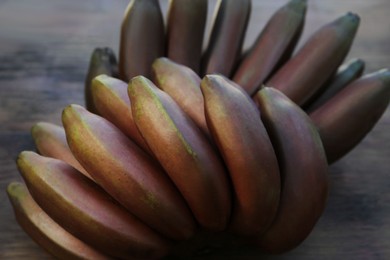 Photo of Tasty purple bananas on wooden table, closeup