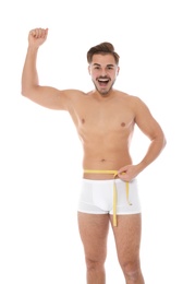 Photo of Fit man measuring his waist on white background. Weight loss