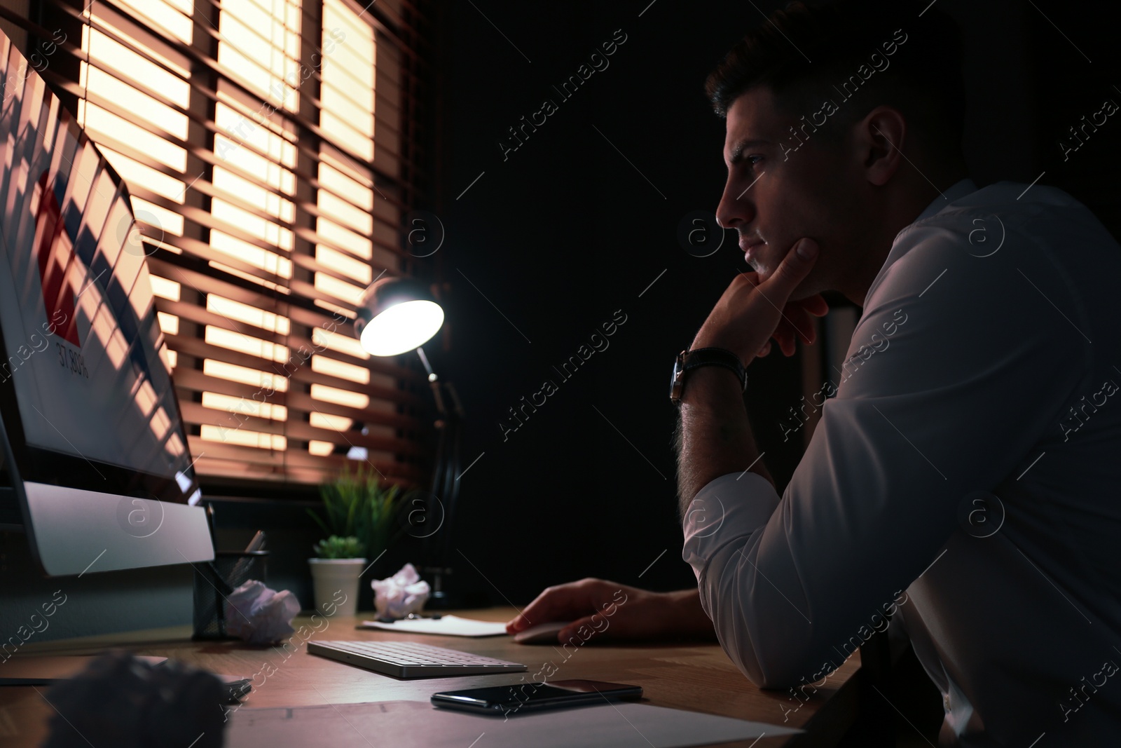 Photo of Businessman stressing out at workplace late in evening
