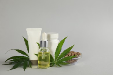 Photo of Composition with CBD oil, THC tincture and hemp leaves on light grey background. Space for text