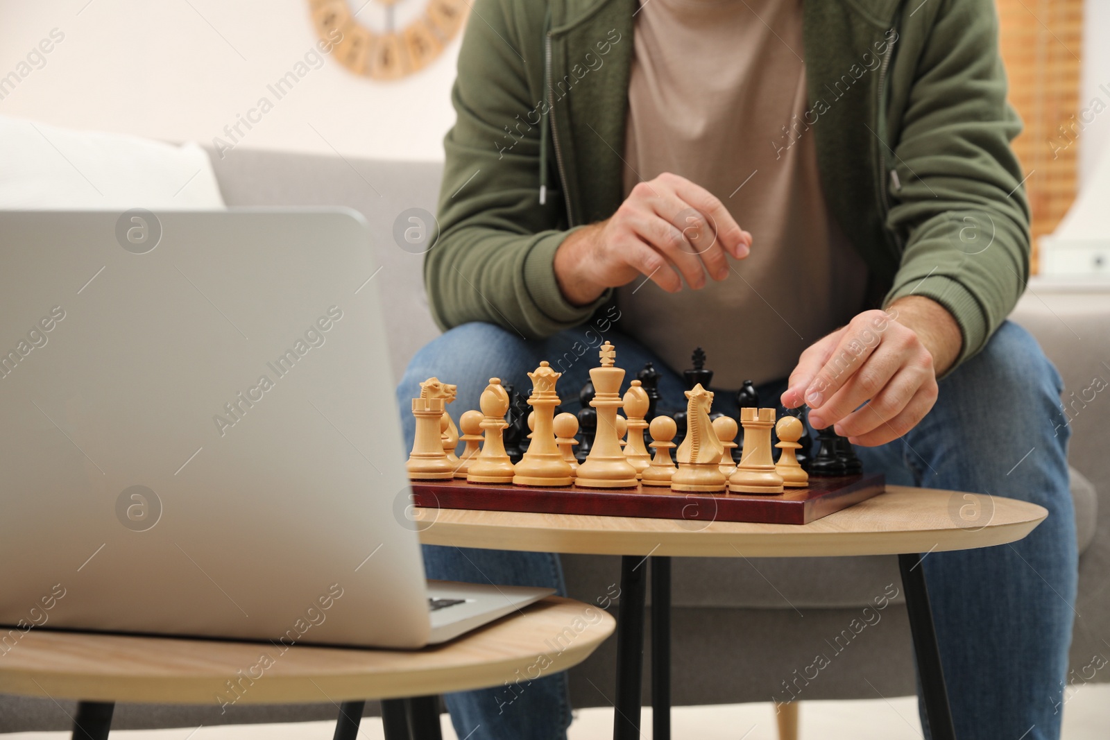 Photo of Man playing chess with partner through online video chat in living room, closeup