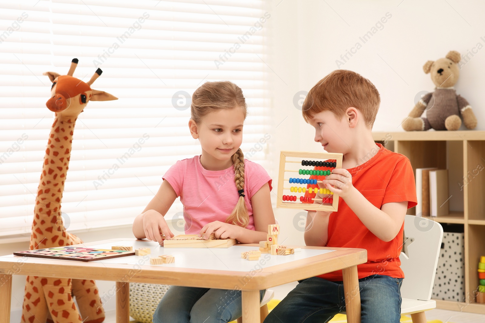 Photo of Children playing with different math game kits at desk in room. Study mathematics with pleasure