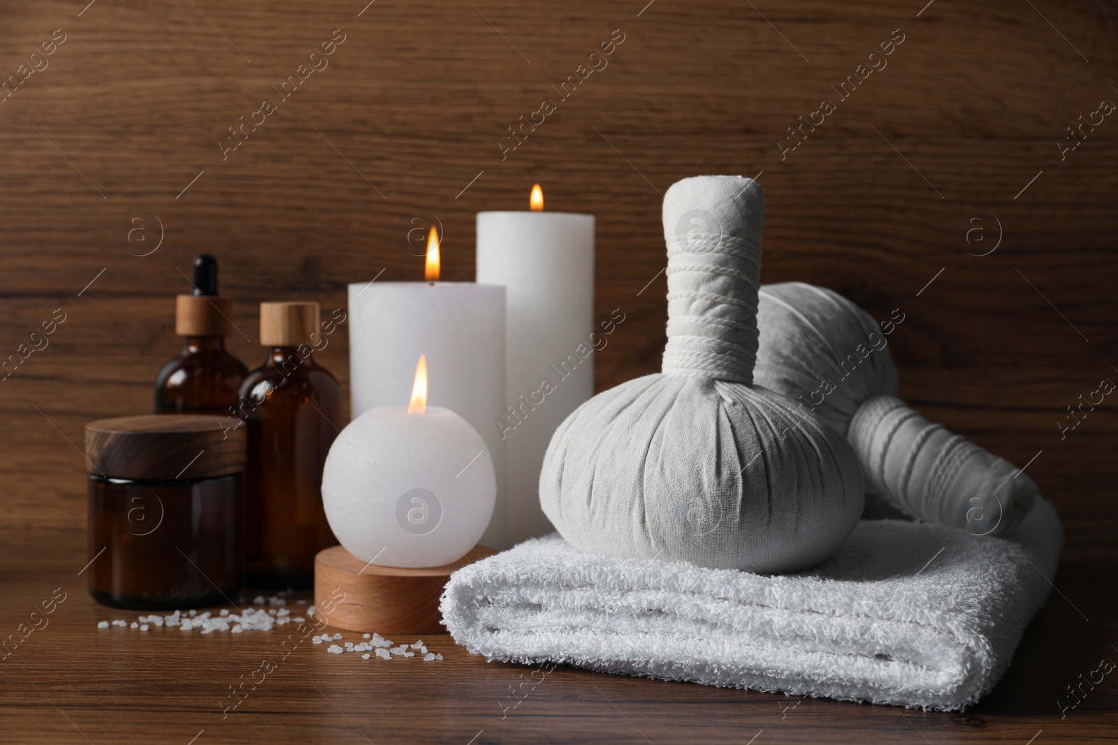 Photo of Beautiful spa composition with different care products and burning candles on wooden table