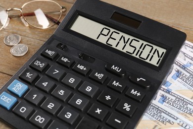 Image of Calculator with word Pension, money and glasses on wooden table, closeup