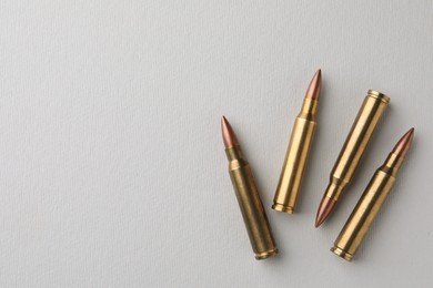 Photo of Brass bullets on white background, flat lay. Space for text