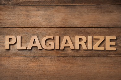 Word Plagiarize made of wooden letters on table, flat lay