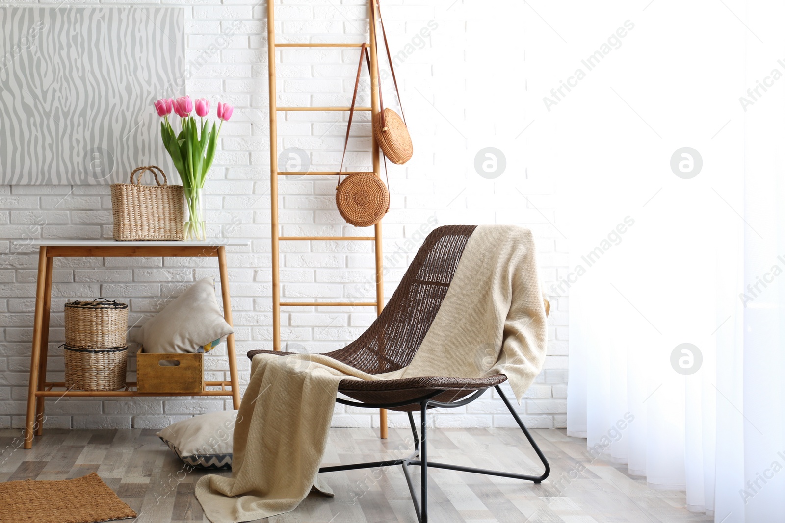 Photo of Stylish living room interior with cozy armchair near brick wall