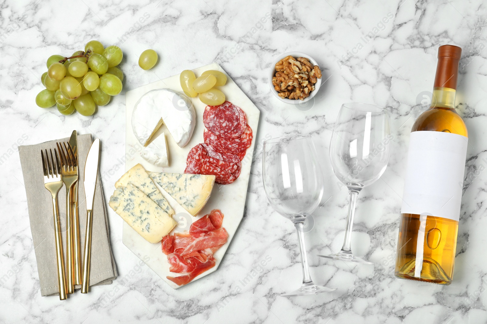 Photo of Flat lay composition with wine and snacks on marble background. Space for design