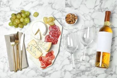 Photo of Flat lay composition with wine and snacks on marble background. Space for design