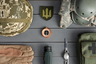 Photo of MYKOLAIV, UKRAINE - SEPTEMBER 26, 2020: Tactical gear and Ukrainian army patch on grey table, flat lay