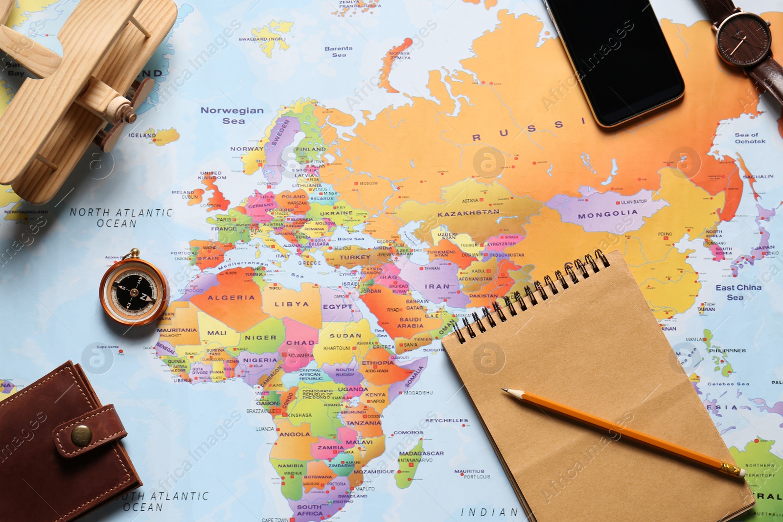 Photo of Flat lay composition with notebook and different items on world map. Trip planning