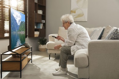 Photo of Elderly woman with poor posture watching TV in living room