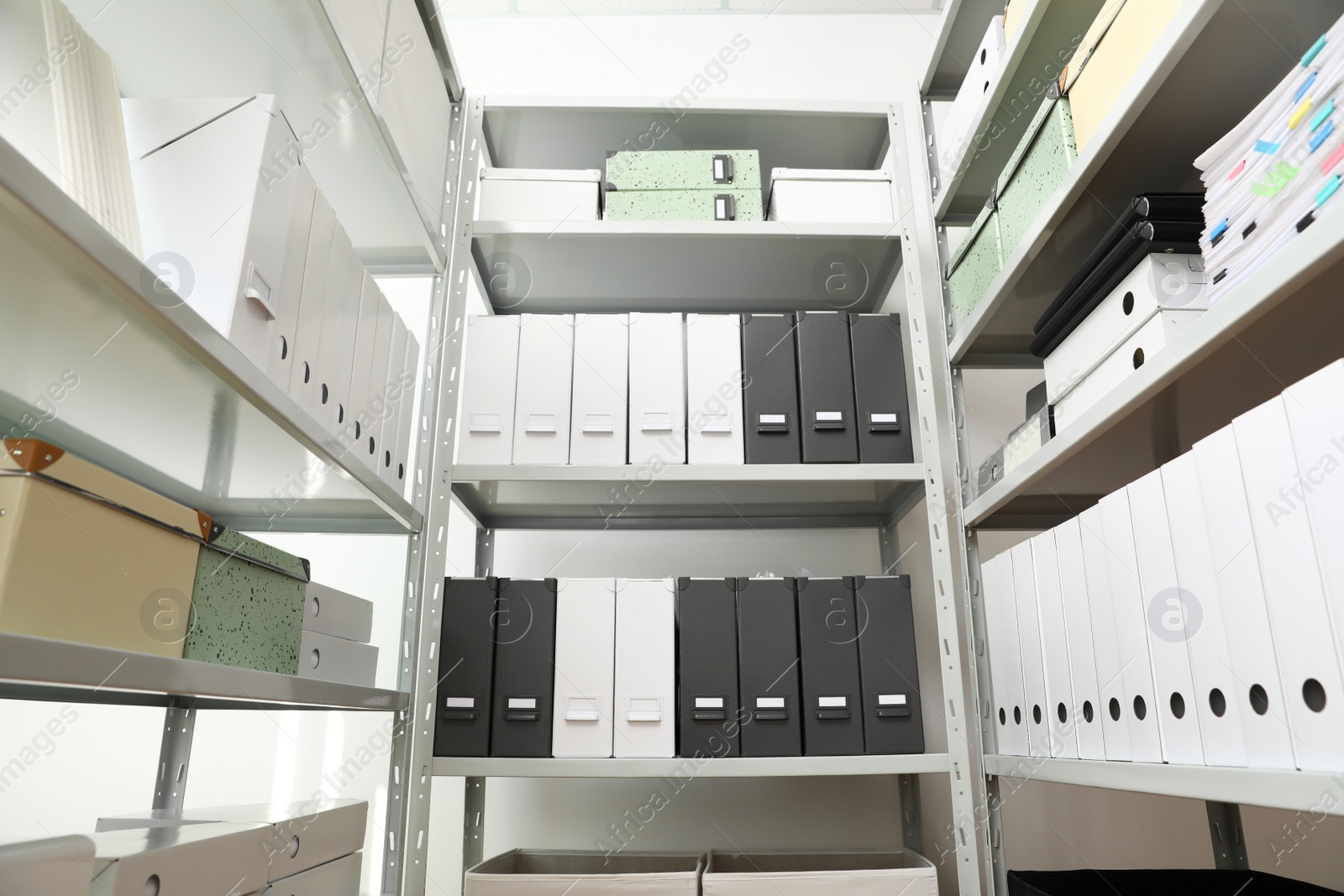 Photo of Folders and boxes with documents on shelves in archive