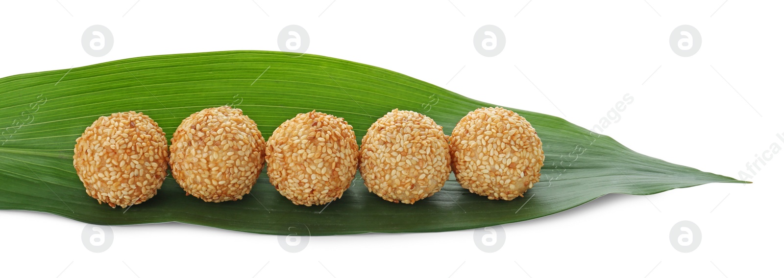 Photo of Delicious sesame balls and green banana leaf on white background