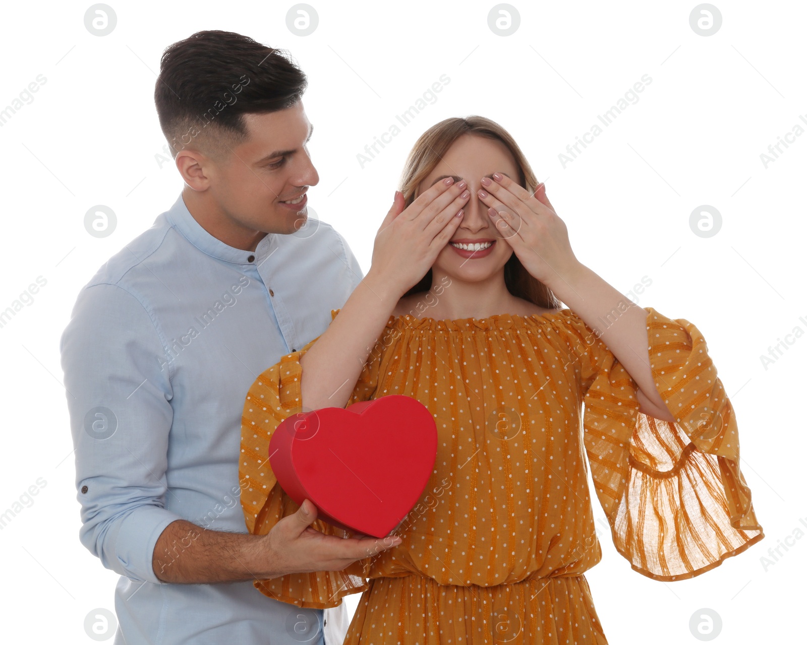 Photo of Man surprising his girlfriend with gift on white background. Valentine's day celebration