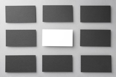 Blank business cards on light grey background, flat lay. Mockup for design