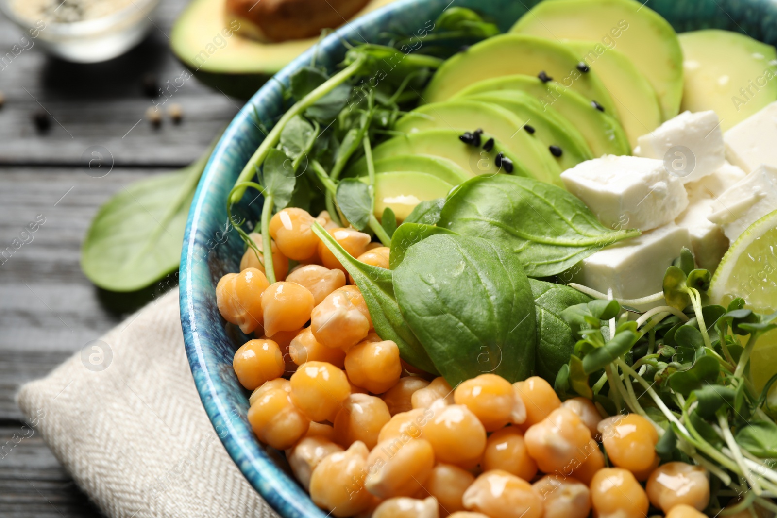 Photo of Delicious avocado salad with chickpea on black table, closeup