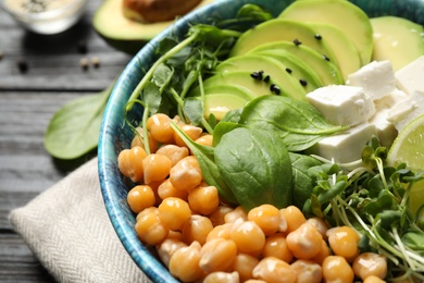 Photo of Delicious avocado salad with chickpea on black table, closeup