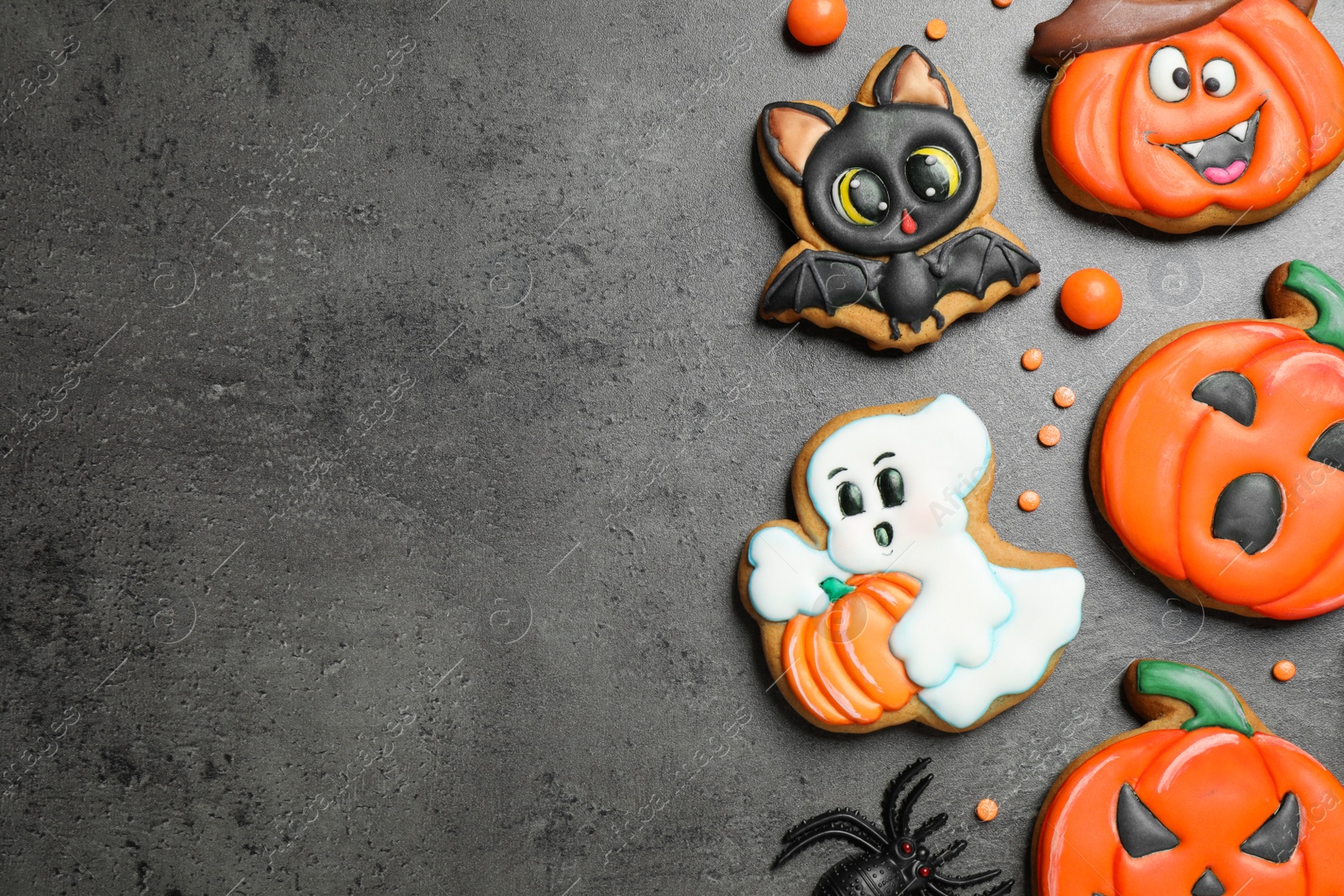 Photo of Tasty cookies and sweets for Halloween party on black table, flat lay. Space for text