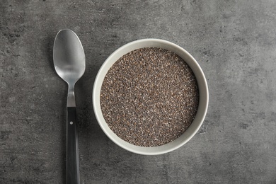 Photo of Bowl with chia seeds and spoon on grey background, flat lay