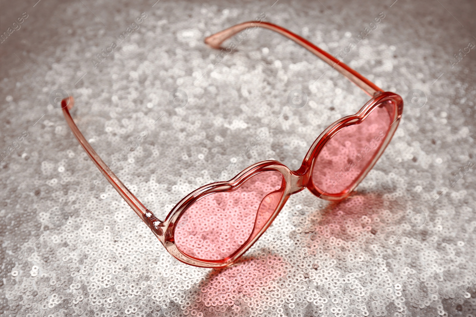 Photo of Pink heart shaped sunglasses on bright background