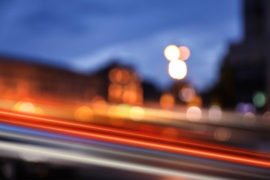 Image of Blurred view of cityscape with light trails at evening, motion blur effect