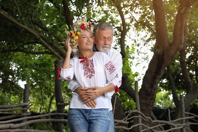 Photo of Happy mature couple in Ukrainian national clothes outdoors