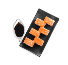 Tasty sushi rolls and soy sauce on white background, top view