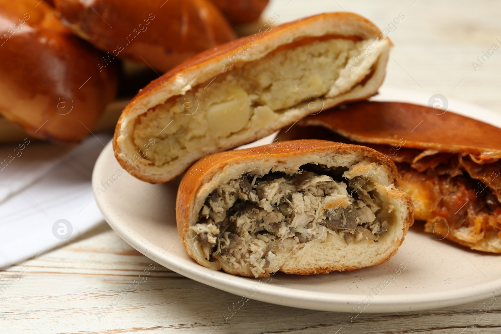 Photo of Delicious baked patties with meat and mushrooms on white wooden table, closeup