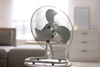 Photo of Modern electric fan on white table in living room