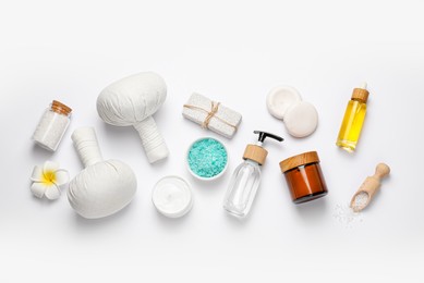 Photo of Beautiful spa composition with herbal massage bags and different care products on white background, flat lay