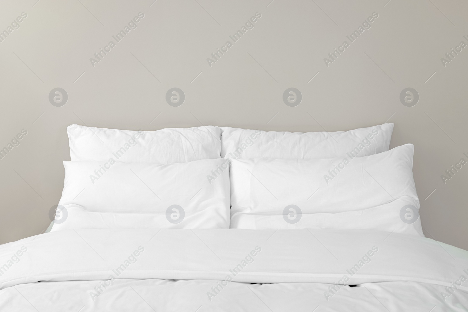 Photo of White soft pillows on cozy bed in room