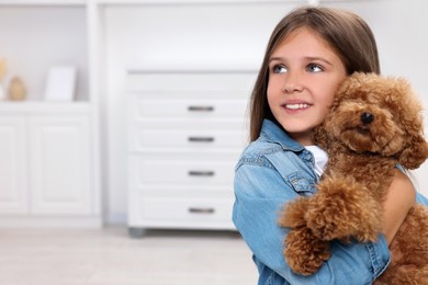 Photo of Little child with cute puppy at home, space for text. Lovely pet