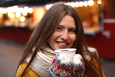 Photo of Happy woman with mulled wine at winter fair