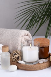Photo of Composition with spa supplies on white table and palm leaf