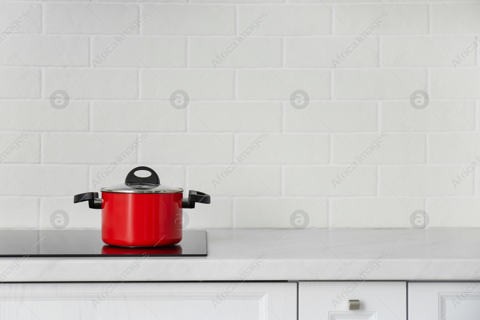 Photo of Saucepot on induction stove in kitchen, space for text