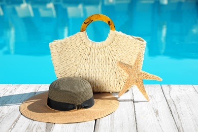 Beach accessories on wooden deck near outdoor swimming pool